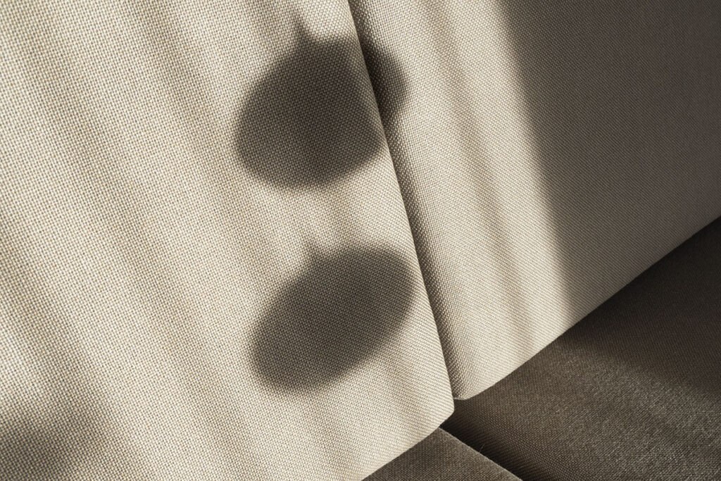 Shadows of lamps cast on a textured beige fabric, creating a minimalist and artistic visual effect.